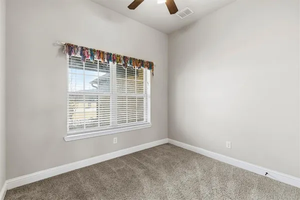 an empty room with a window and a fan