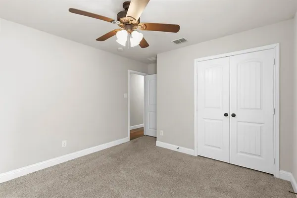 an empty room with a window and a fan