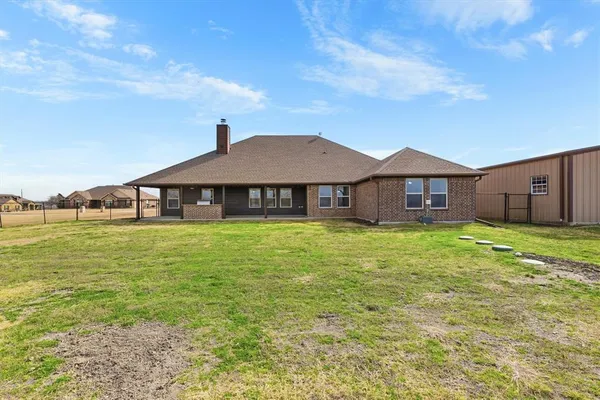 a front view of a house with a yard table and chairs