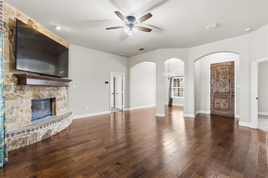 505 Water Fall Lane Nevada, TX 75173 - Photo 4 of 36 a view of a livingroom with a fireplace a ceiling fan and wooden floor