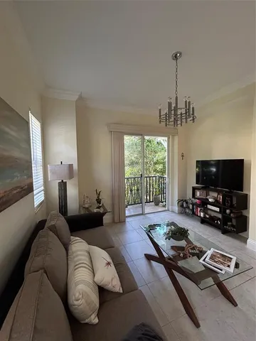 a living room with furniture a flat screen tv and a large window