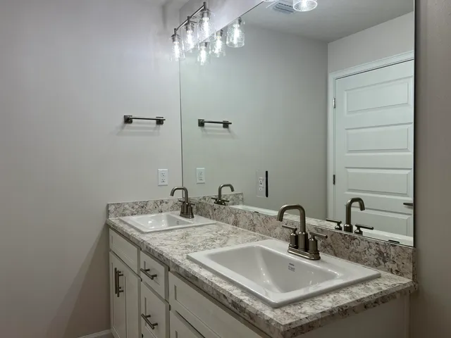 a bathroom with a granite countertop sink and a mirror