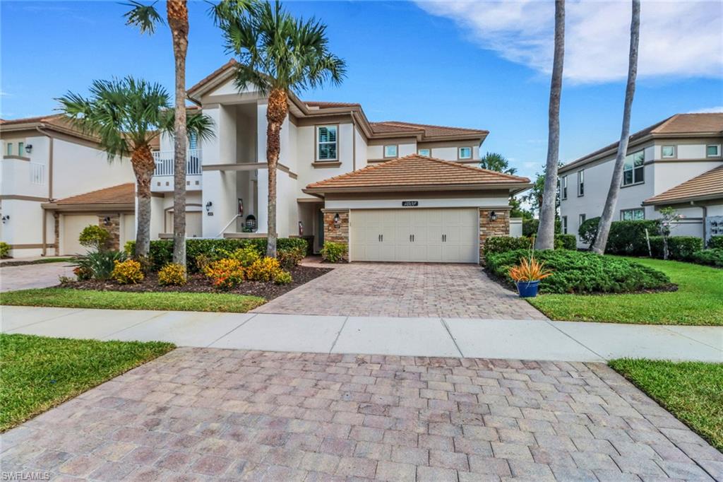 9208 Quartz Lane, Unit 102 Naples, FL 34120 - Photo 1 of 31 a front view of a house with a garden and plants