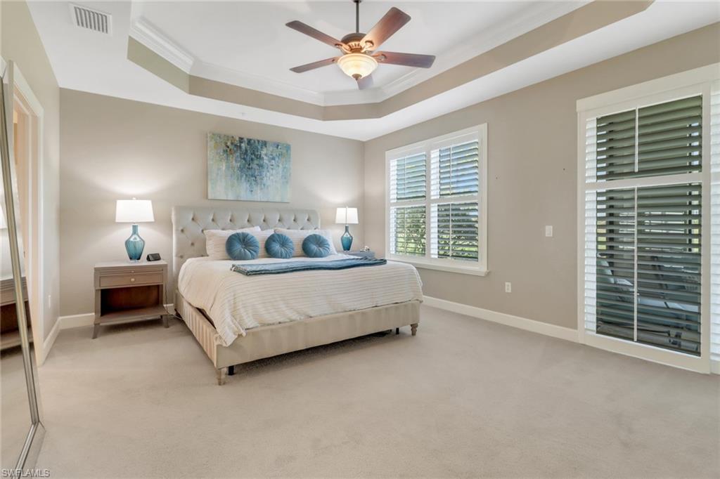 9208 Quartz Lane, Unit 102 Naples, FL 34120 - Photo 12 of 31 a bedroom with a bed chandelier and a large window