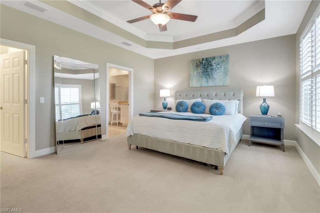 9208 Quartz Lane, Unit 102 Naples, FL 34120 - Photo 13 of 31 a bedroom with a bed a ceiling fan and a rug