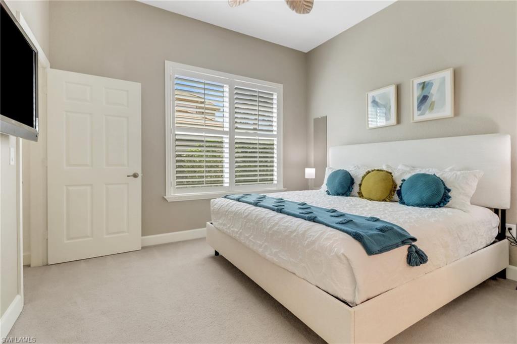 9208 Quartz Lane, Unit 102 Naples, FL 34120 - Photo 17 of 31 a bed sitting in a bedroom next to a window