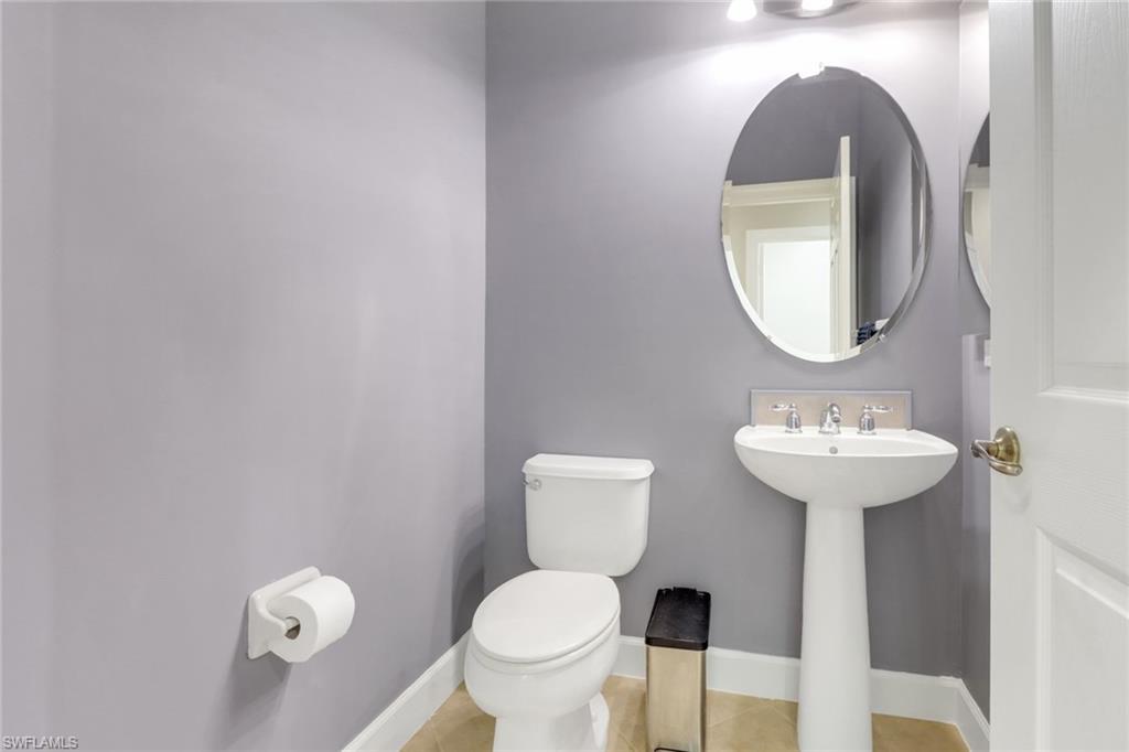 9208 Quartz Lane, Unit 102 Naples, FL 34120 - Photo 20 of 31 a bathroom with a toilet sink and mirror