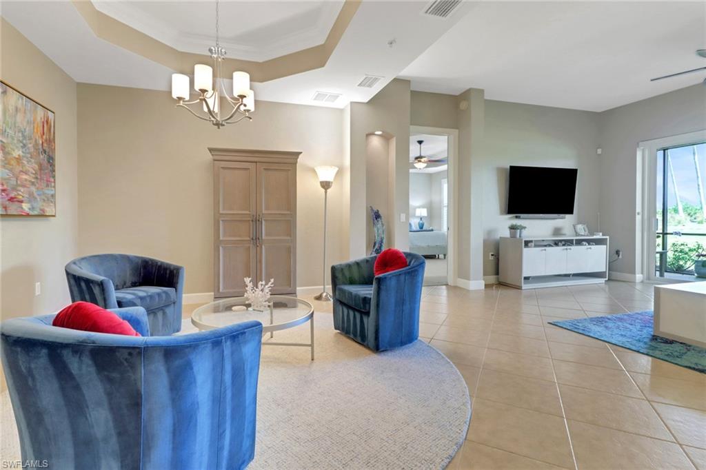 9208 Quartz Lane, Unit 102 Naples, FL 34120 - Photo 4 of 31 a living room with furniture and a flat screen tv
