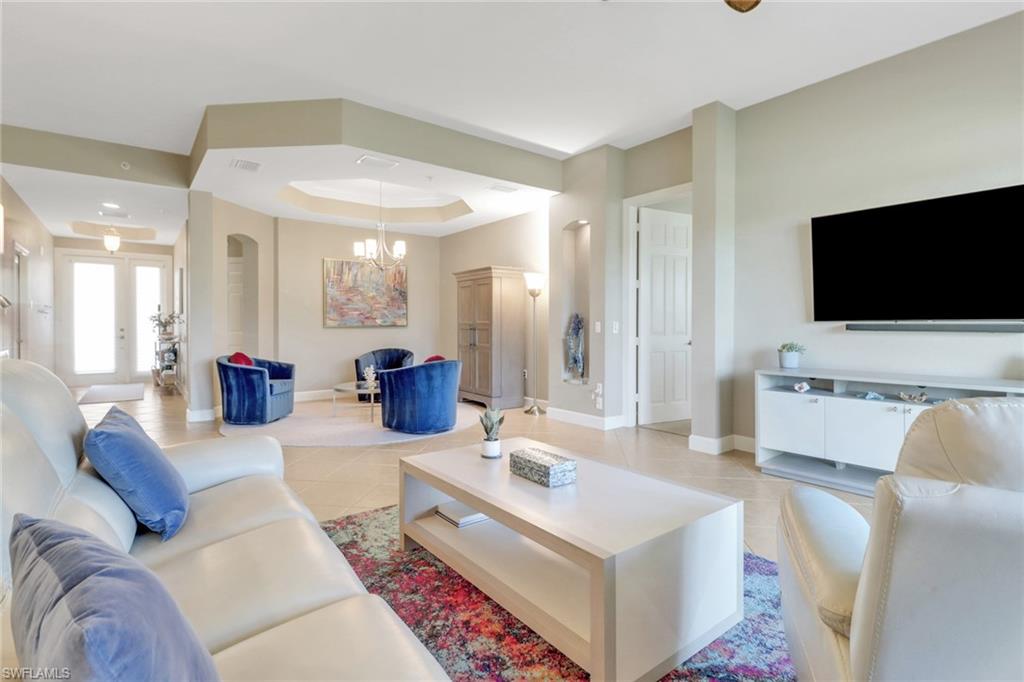 9208 Quartz Lane, Unit 102 Naples, FL 34120 - Photo 6 of 31 a living room with furniture and a flat screen tv