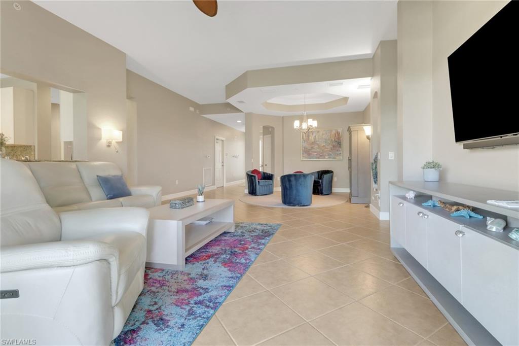 9208 Quartz Lane, Unit 102 Naples, FL 34120 - Photo 7 of 31 a large room with a large window and a flat screen tv