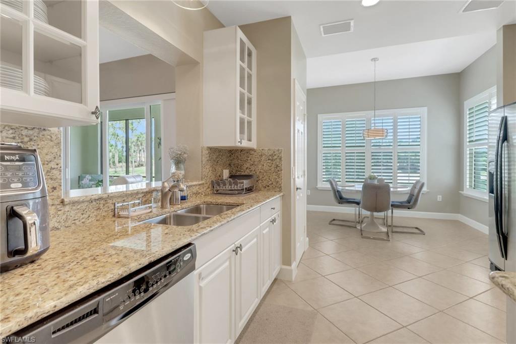9208 Quartz Lane, Unit 102 Naples, FL 34120 - Photo 8 of 31 a kitchen with a sink and chairs