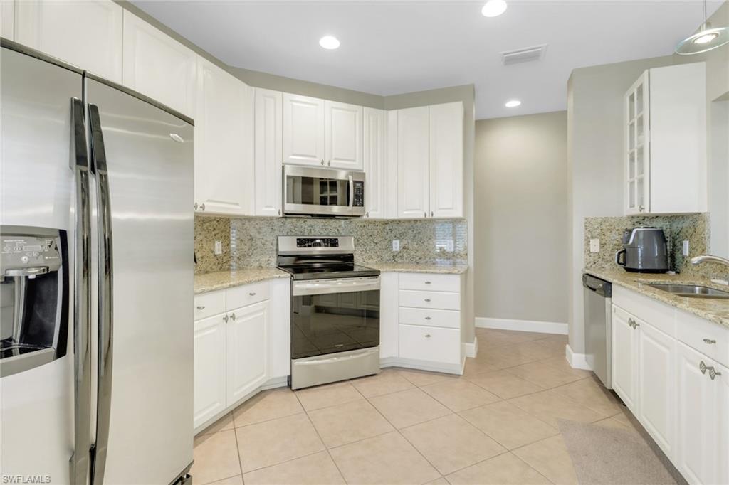 9208 Quartz Lane, Unit 102 Naples, FL 34120 - Photo 10 of 31 a kitchen with stainless steel appliances granite countertop a refrigerator sink and stove