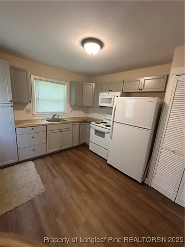 a kitchen with granite countertop a sink and a stove top oven