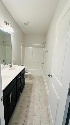 232 Chateau Way Angier, NC 27501 - Photo 6 of 23 a bathroom with a sink a mirror and a bathtub