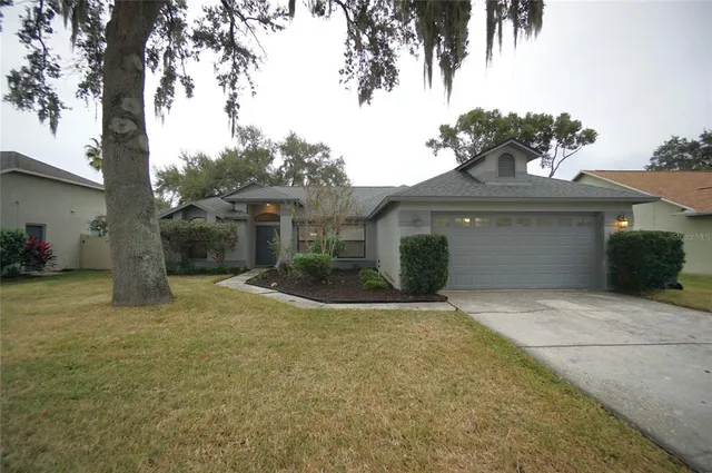 a front view of a house with a yard and potted plants