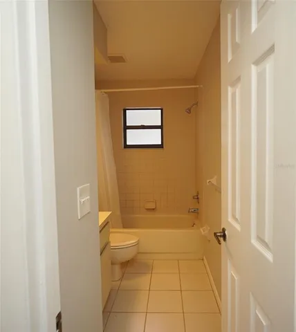 a view of a room with a chandelier fan and windows