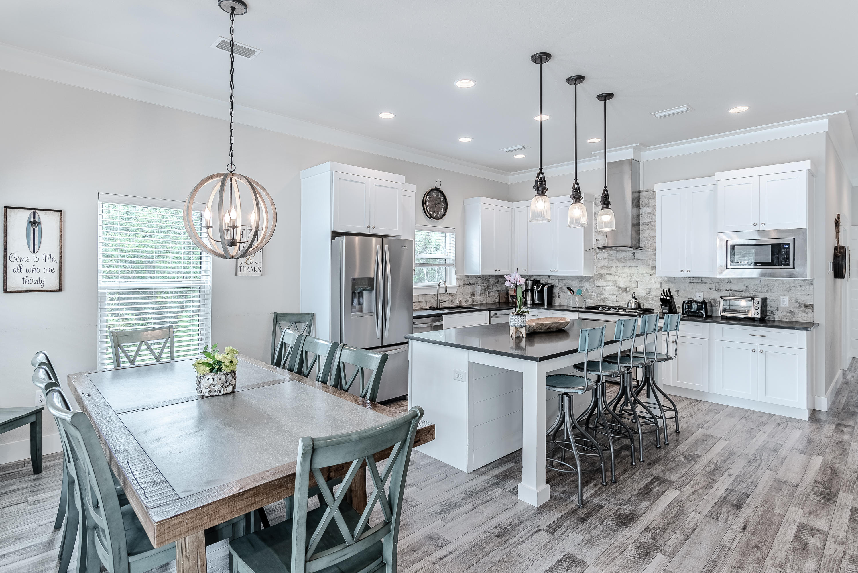 109 Santa Clara Street Santa Rosa Beach, FL 32459 - Photo 5 of 41 a kitchen with stainless steel appliances granite countertop a stove a refrigerator a kitchen island a dining table and chairs