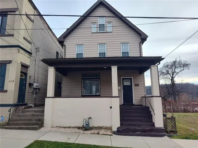 a view of a house with wooden fence and large windows