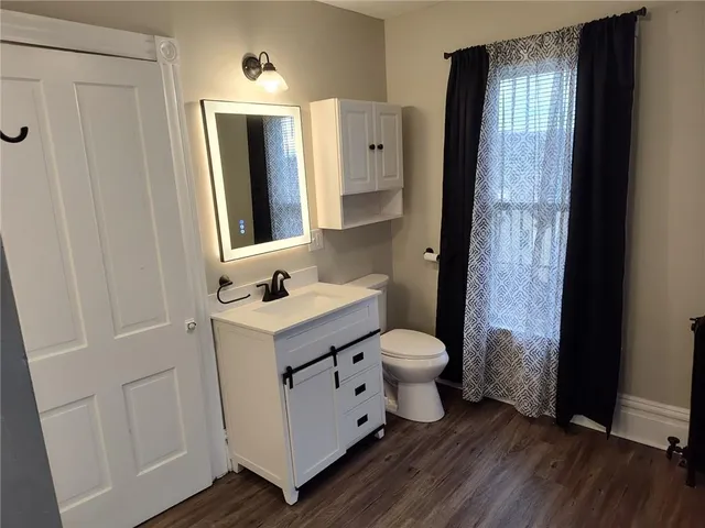 a bathroom with a sink and glass door with wooden floor