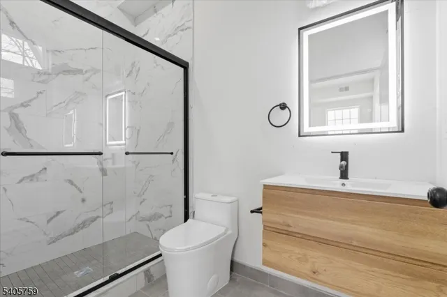 a bathroom with a toilet a sink and mirror