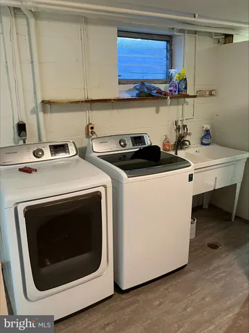 a utility room with stainless steel appliances granite countertop a stove a sink and a microwave