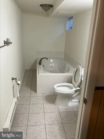 a white toilet sitting next to a bath tub