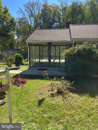 a view of house with garden space and sitting area