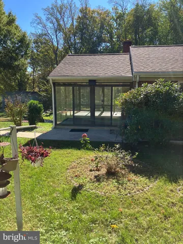 a view of house with garden space and sitting area