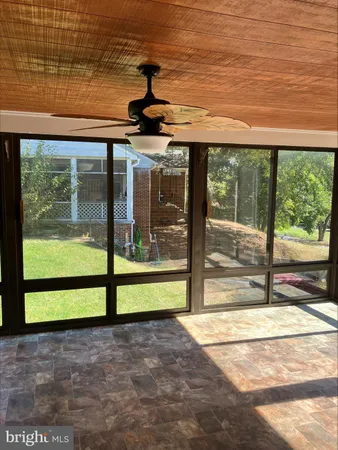a view of a porch with a floor to ceiling window next to a yard