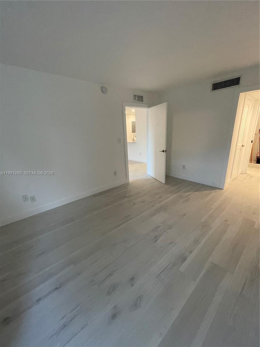 2160 Southwest 16th Avenue, Unit 115 Miami, FL 33145 - Photo 11 of 31 an empty room with wooden floor and windows