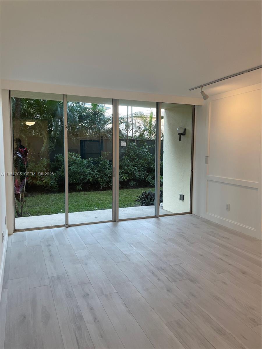 2160 Southwest 16th Avenue, Unit 115 Miami, FL 33145 - Photo 19 of 31 a view of an empty room with wooden floor and a floor to ceiling window