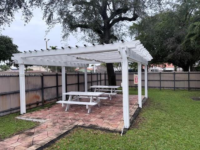 2160 Southwest 16th Avenue, Unit 115 Miami, FL 33145 - Photo 26 of 31 a view of a patio with table and chairs under an umbrella with large trees