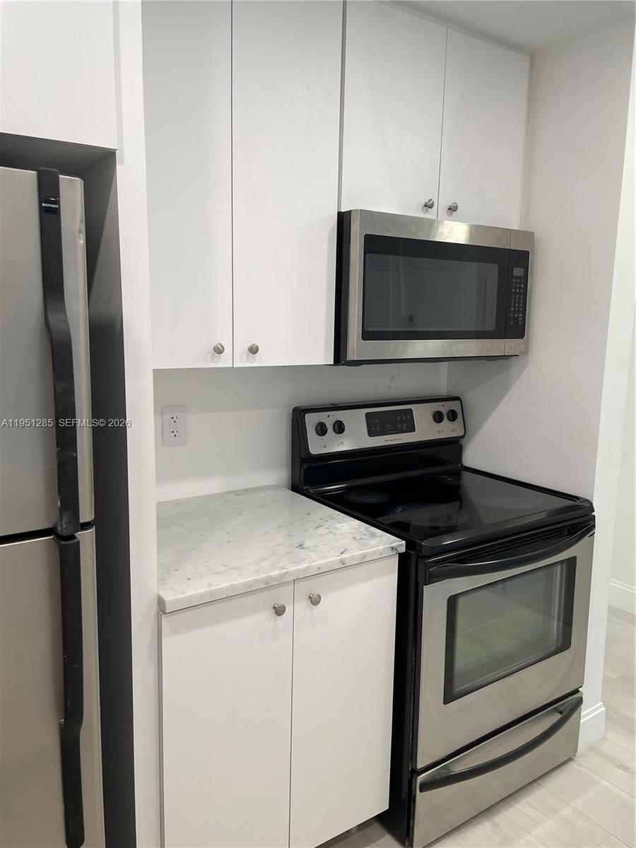 2160 Southwest 16th Avenue, Unit 115 Miami, FL 33145 - Photo 7 of 31 a kitchen with a stove and a microwave