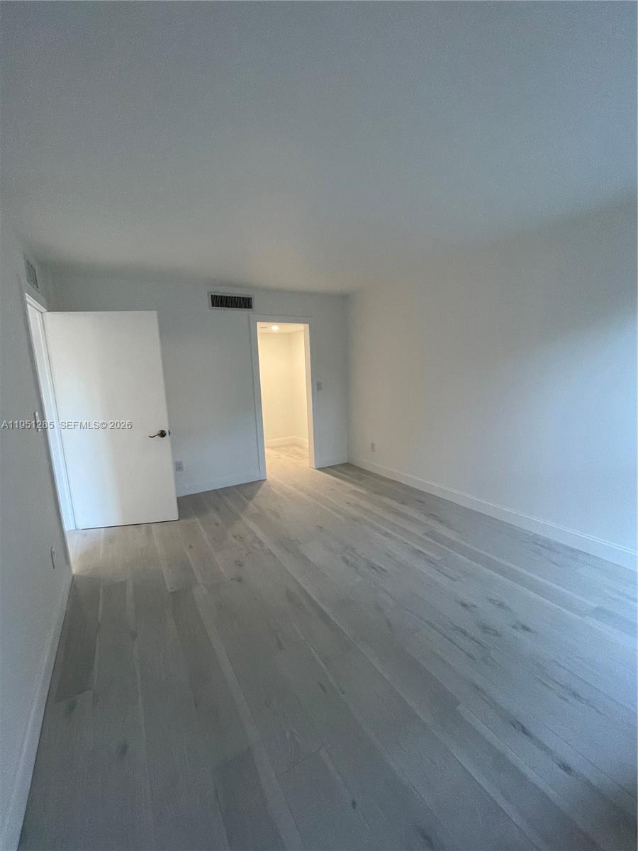 2160 Southwest 16th Avenue, Unit 115 Miami, FL 33145 - Photo 10 of 31 an empty room with wooden floor and windows