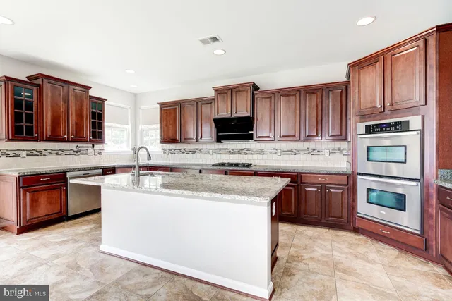a kitchen with stainless steel appliances granite countertop a stove sink microwave and cabinets