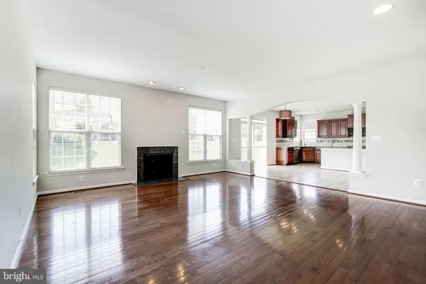 a view of empty room with wooden floor and fireplace