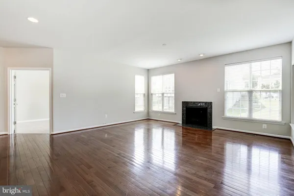 an empty room with wooden floor and fireplace