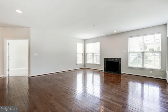 an empty room with wooden floor and fireplace
