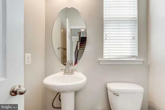 a bathroom with a toilet a sink and a mirror