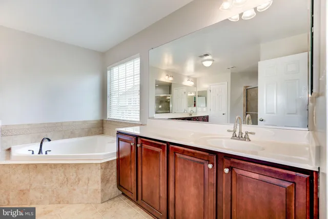 a bathroom with a tub sink and mirror
