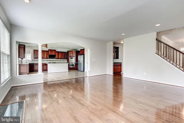 a view of a living room with wooden floor and white walls