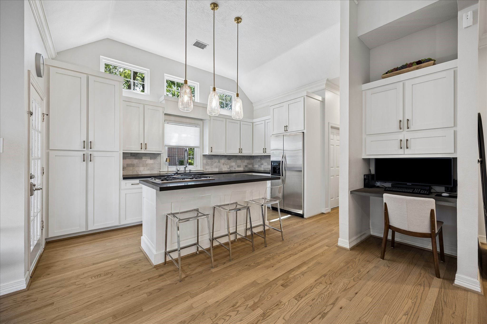 4131 Sunset Boulevard Houston, TX 77005 - Photo 11 of 38 a kitchen with stainless steel appliances granite countertop a refrigerator a stove and white cabinets with wooden floor