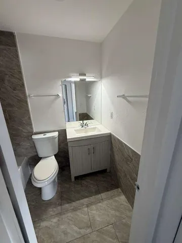 a bathroom with a sink a toilet and a mirror