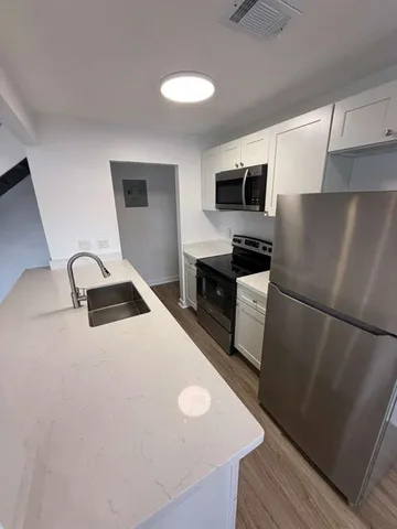 a kitchen with a refrigerator a stove and a sink