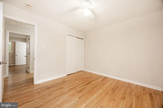 a view of a room with wooden floor and a ceiling fan