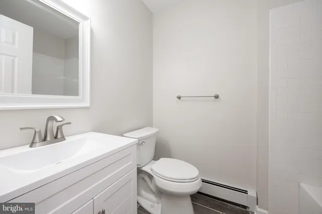 a bathroom with a sink a toilet and a mirror