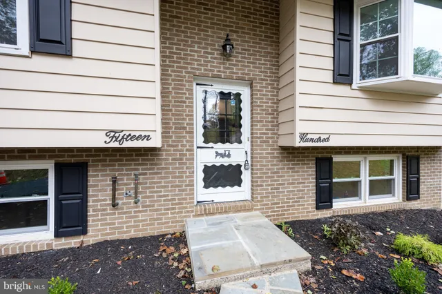 a view of a house with a yard and large tree