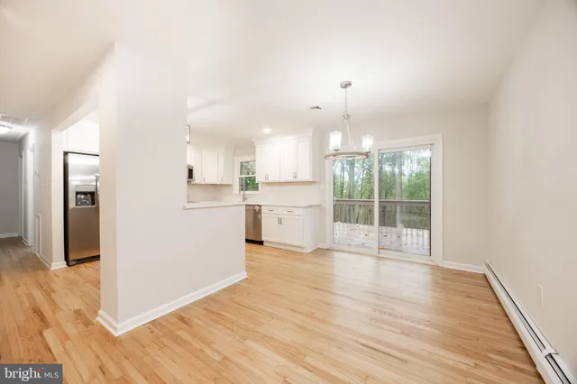 a view of a kitchen with wooden floor and a window