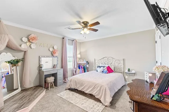 a bedroom with a bed a study table and large window