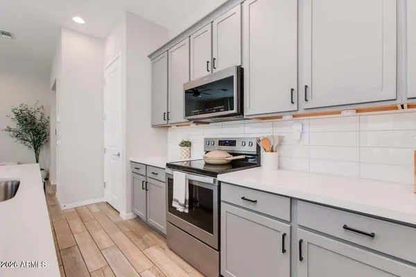 a kitchen with stainless steel appliances white cabinets and a stove top oven